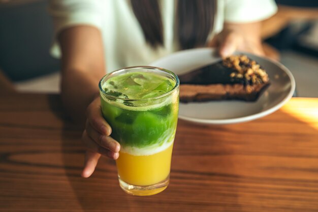 Closeup limonada e bolo de chocolate em mãos femininas