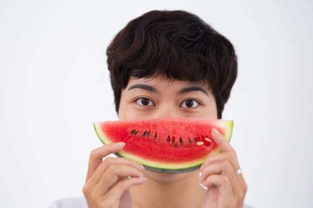 Closeup of serious asian woman holding watermelon