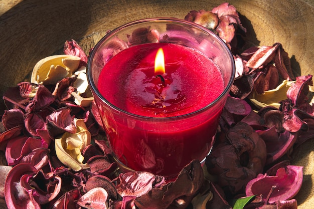 Foto grátis closeup queimando vela vermelha entre pétalas de rosa