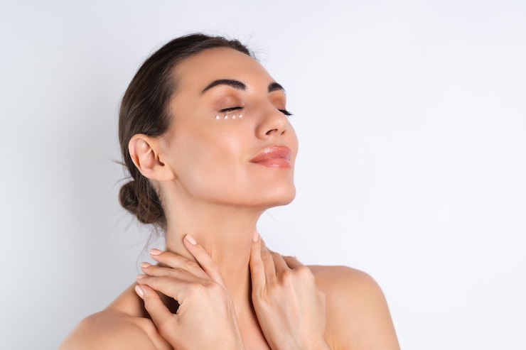 Foto grátis closeup retrato de beleza de uma mulher de topless com pele perfeita e maquiagem natural com pontos de creme antienvelhecimento para hidratar e firmar a pele sob os olhosx9