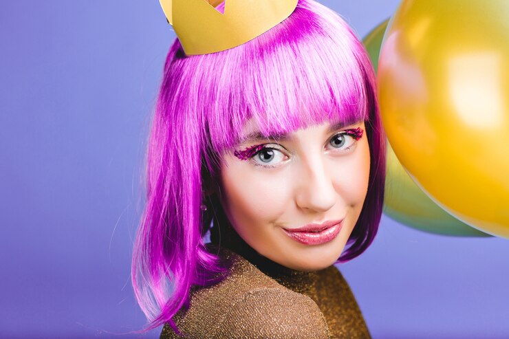 Foto grátis closeup retrato incrível jovem alegre com cabelo roxo cortado, coroa de ouro e balões comemorando o carnaval, festa de ano novo. sorriso encantador, maquiagem com enfeites, felicidade.