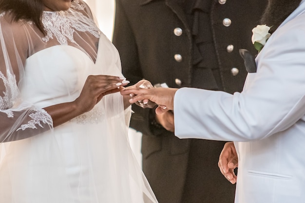 Closeup tiro da noiva colocando a aliança no dedo anelar do noivo em um casamento