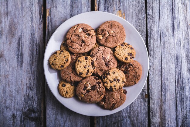 Closeup tiro de biscoitos de chocolate em um prato branco sobre uma superfície de madeira