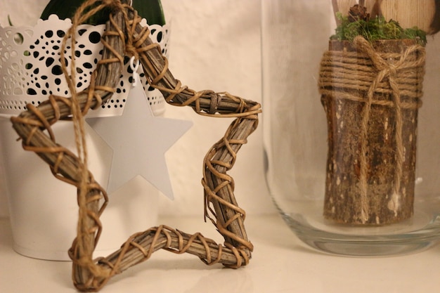 Closeup tiro de decorações rústicas de estrela de vime e madeira com fio de juta em um copo