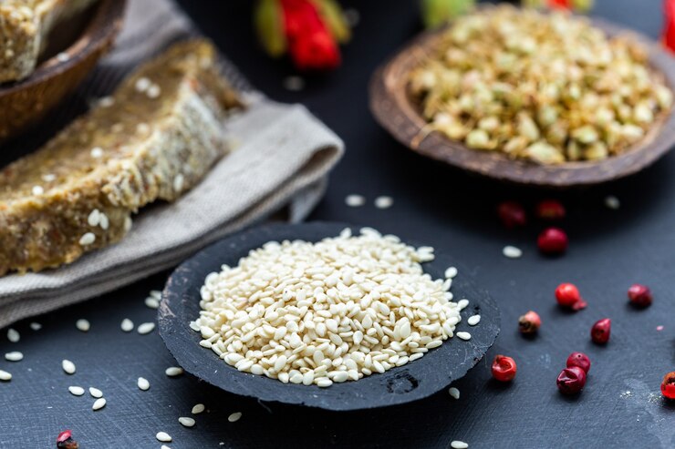 Foto grátis closeup tiro de gergelim em uma tigela preta e pão vegan