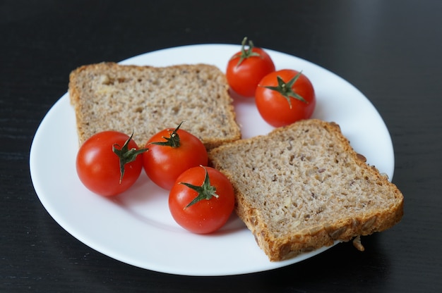 Closeup tiro de tomate cereja e uma fatia de pão no prato