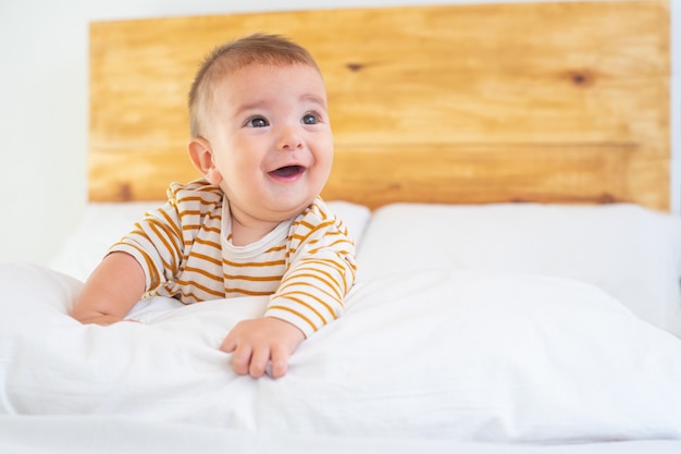 Closeup tiro de um lindo bebê sorridente em uma cama