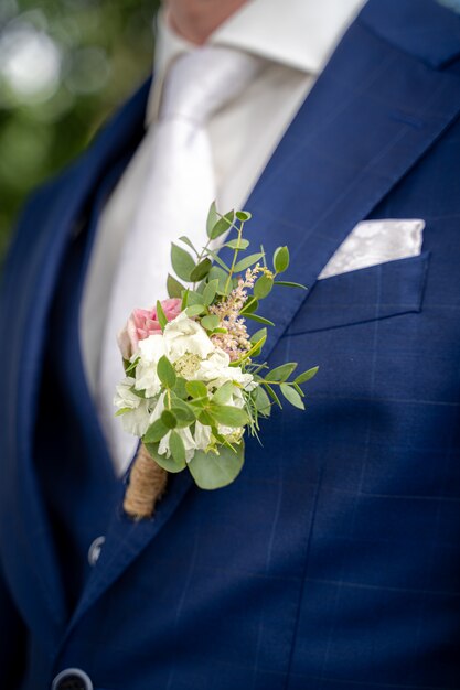 Closeup tiro de um noivo com um terno azul na hora de um casamento