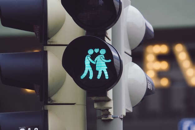 Closeup tiro de um semáforo mostrando um homem e uma mulher de mãos dadas