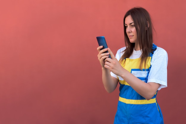 Foto grátis closeup tiro de uma jovem mulher com seu smartphone posando para a câmera