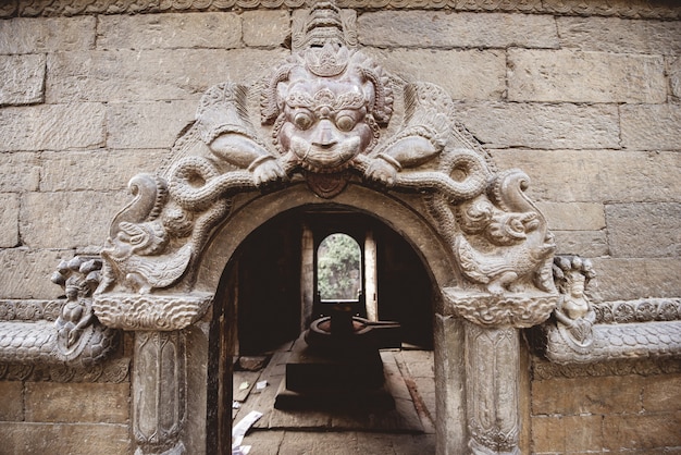 Foto grátis closeup tiro de uma porta em arco com escultura em um templo hindu no nepal