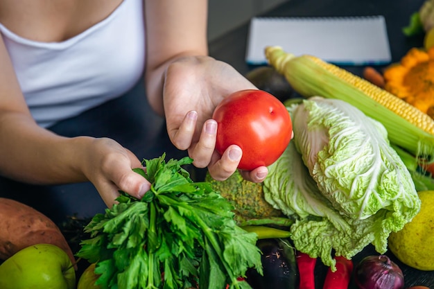 Closeup tomate e salsa nas mãos femininas na cozinha