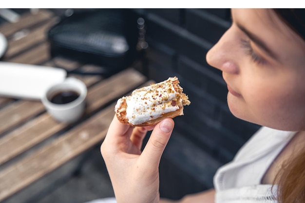 Foto grátis closeup uma mulher come um eclair apetitoso