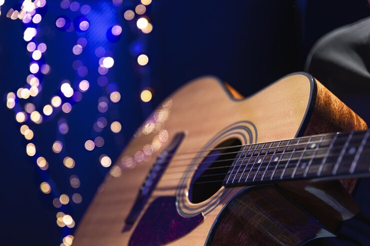 Foto grátis closeup violão acústico em um fundo escuro com luzes bokeh