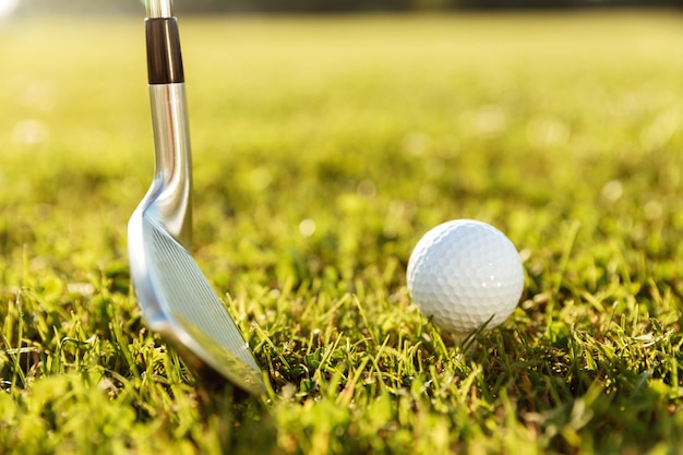 Clube de golfe e uma bola na grama verde