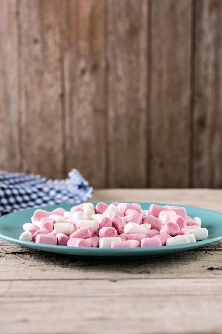 Foto grátis cobertura de marshmallows doces em um prato azul na mesa de madeira