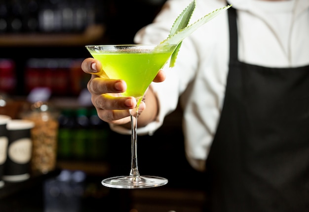 Cocktail amarelo na mão do barman
