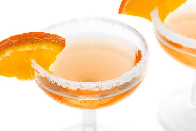 Cocktail clássico de sidecar com um aro de açúcar isolado no fundo branco