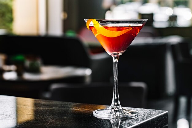 Cocktail de álcool com vista lateral para casca de laranja