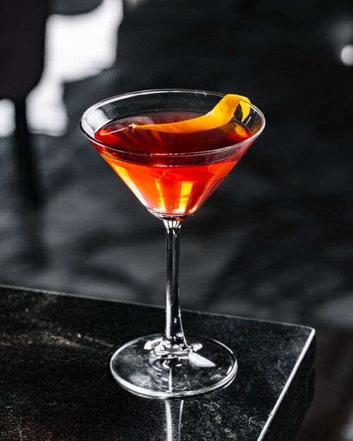 Cocktail de álcool com vista lateral para casca de laranja