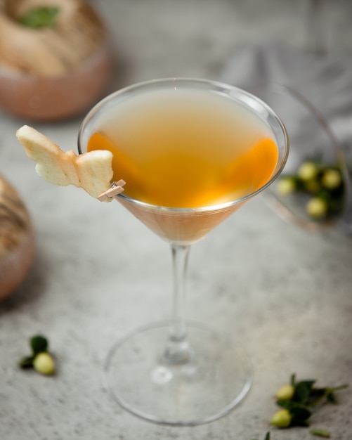 cocktail de cor amarela com fatia de maçã