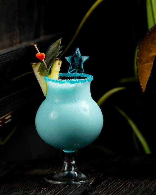 Cocktail de cor azul com uma fatia de abacaxi