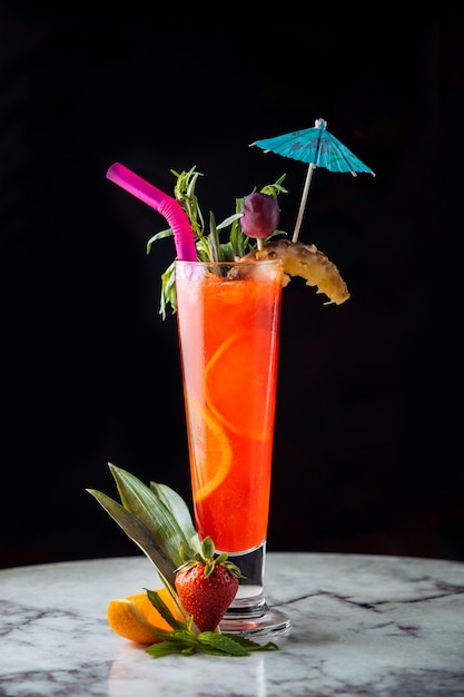 Foto grátis cocktail de suco de laranja com acessórios coloridos.