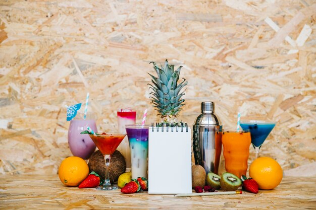 Cocktail e frutas tropicais com bloco de notas