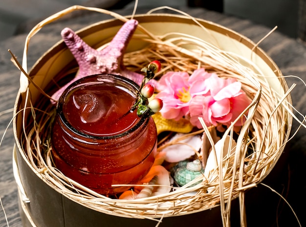 Cocktail em jarra colocada em caixa com conchas e estrelas do mar