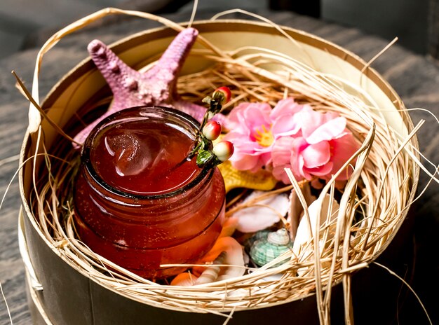 Cocktail em jarra colocada em caixa com conchas e estrelas do mar