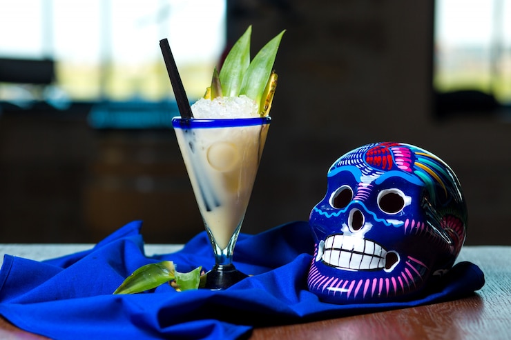 Foto grátis cocktail leitoso decorado com abacaxi, ao lado do crânio mexicano azul