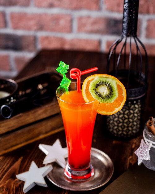 Cocktail refrescante decorado com fatias de laranja e kiwi