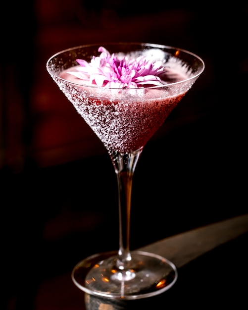 Cocktail rosa decorado com flor em copo de martini