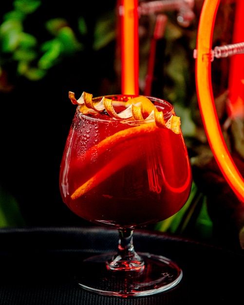 Cocktail vermelho com limão em cima da mesa