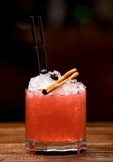 Cocktail vermelho frio com paus de canela