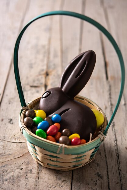 Coelhinho da Páscoa de chocolate e ovos coloridos na mesa de madeira