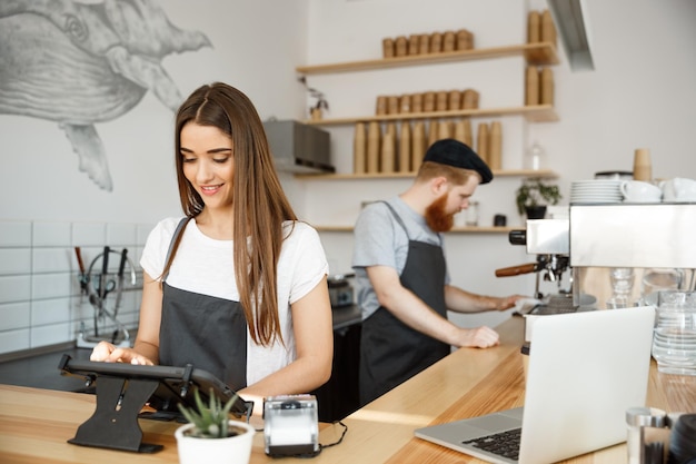 Coffee Business Concept belo barman caucasiano barista ou gerente Postando o pedido no menu do tablet digital no café moderno