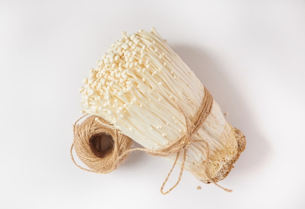 Cogumelo branco com agulha dourada ou cogumelo enoki isolado na superfície branca