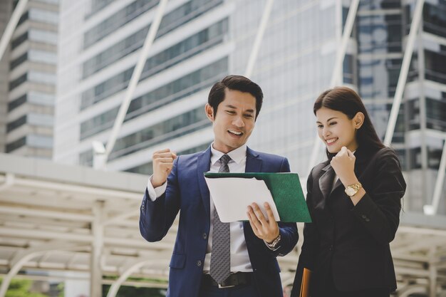 Colega comercial falando e visualizando documentos ao ar livre