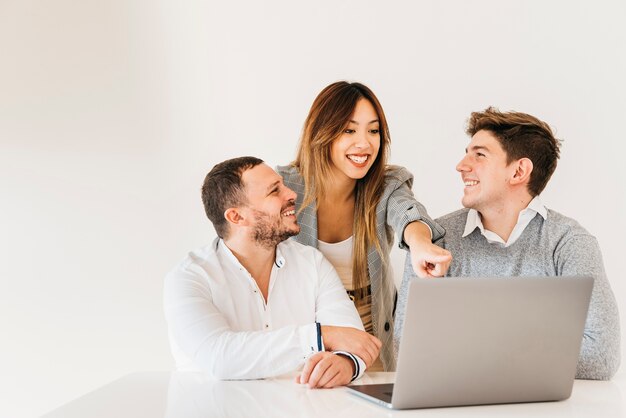 Colegas alegres, olhando para o projeto no laptop no escritório