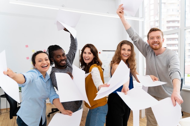 Colegas com folhas de papel tiro médio