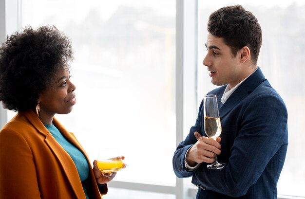 Colegas de tiro médio com bebidas conversando