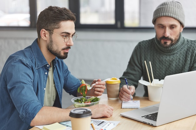 Colegas de trabalho almoçando no escritório