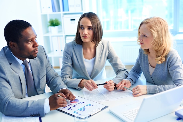 Colegas de trabalho com documentos estatísticos