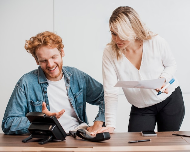 Colegas de trabalho conversando ao telefone no viva-voz