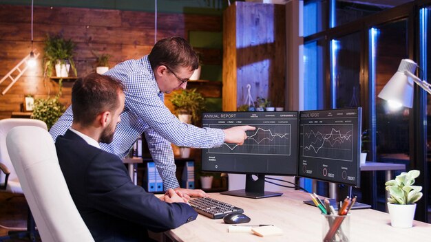 Colegas de trabalho discutindo juntos em um escritório à noite, Trabalho em equipe e parceria