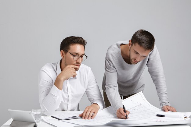 Colegas de trabalho do sexo masculino cuidando da papelada