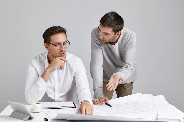 Colegas de trabalho do sexo masculino cuidando da papelada