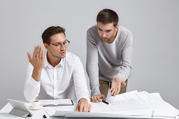 Colegas de trabalho do sexo masculino cuidando da papelada