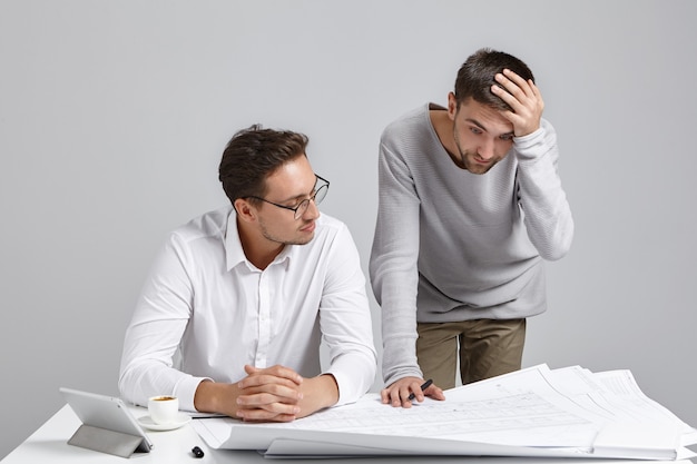 Colegas de trabalho do sexo masculino cuidando da papelada